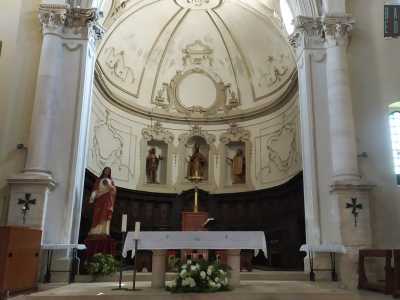 ...� dominata dal presbiterio e termina con l�abside. Conserva al centro la cattedra vescovile e l�altare maggiore di marmo attorno a cui si dispongono i seggi in legno del coro, su cui si stagliano le statue dorate di San Filippo Neri, San Nicola di Bari e San Giovanni